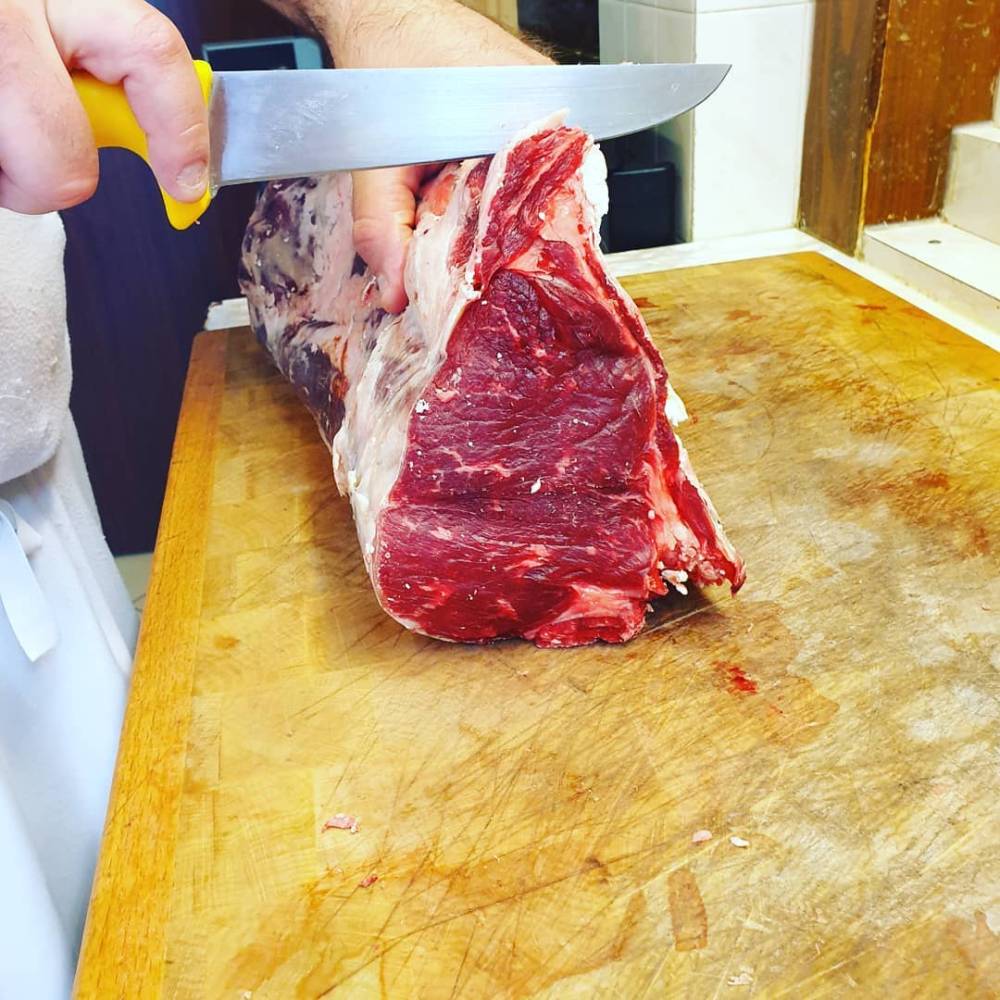 Boucher coupant une pièce de boeuf