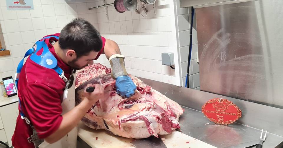 Boucher coupant une pièce de boeuf